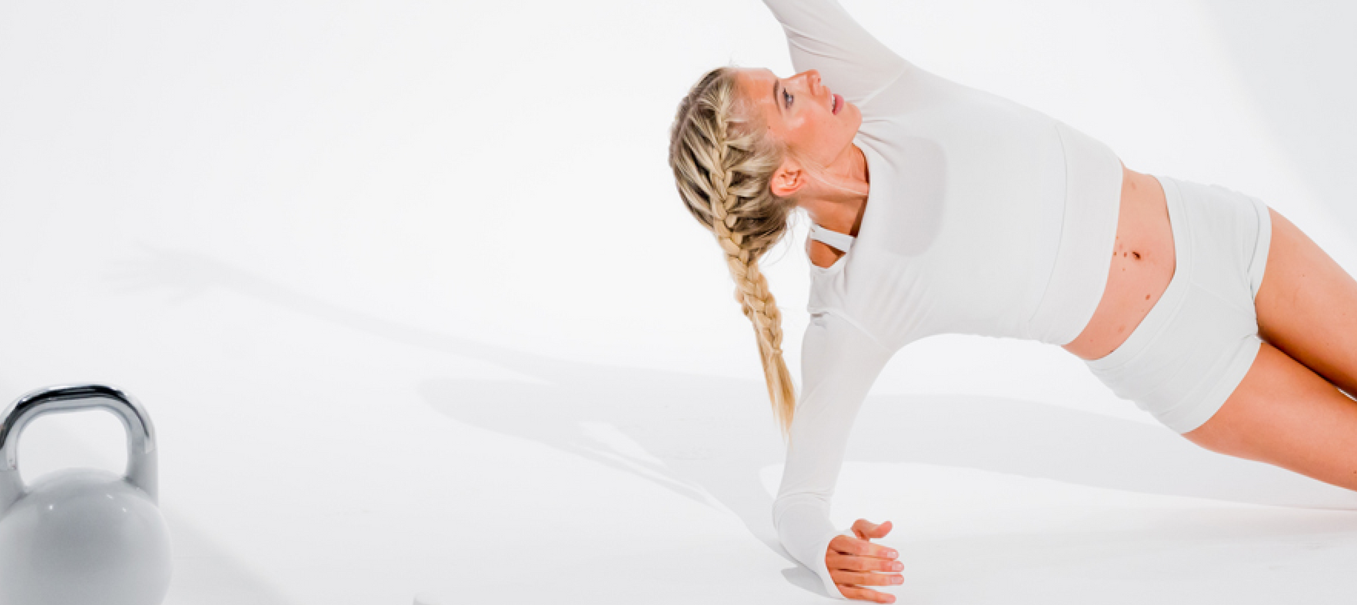 Mujer vestida de blanco realizando una pose de yoga